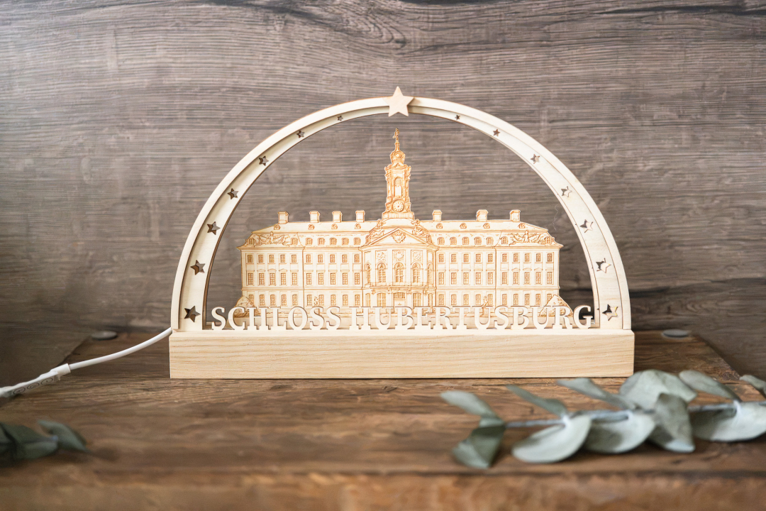 LED-Schwibbogen komplett aus Holz mit gravierter Ansicht von Schloss Hubertusburg und dem Schriftzug „Schloss Hubertusburg", umrahmt von Sternen, warmweißes Licht